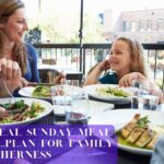 A happy family enjoying a Sunday meal together around a table.