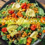 A vibrant Mediterranean Chickpea Khichdi salad with avocado slices, cherry tomatoes, chickpeas, and herbs in a bowl.