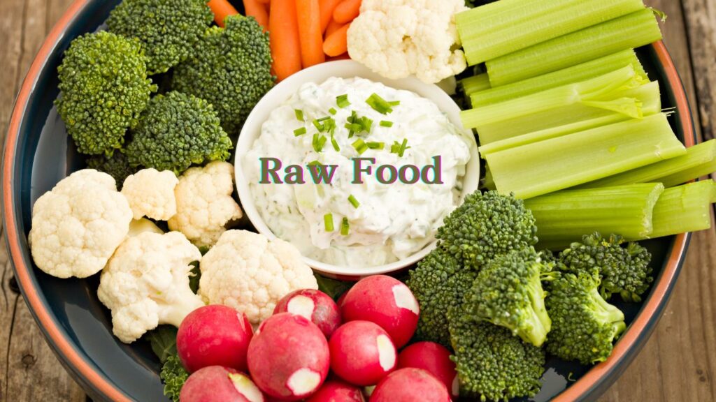 A vibrant platter of raw vegetables with a bowl of dip labeled “Raw Food.”