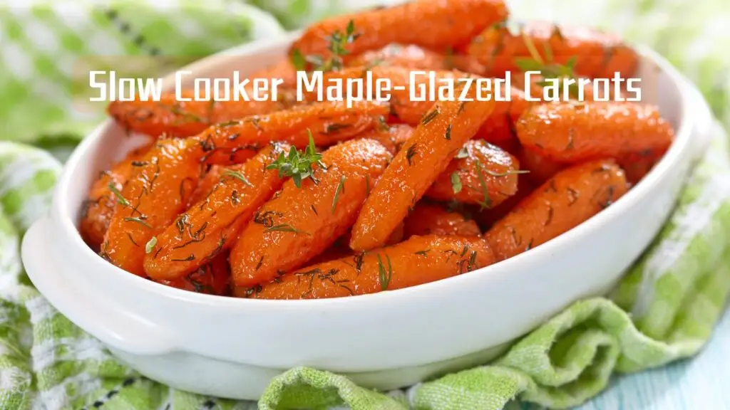 A white oval dish filled with orange maple-glazed carrots garnished with herbs, placed on a green cloth.