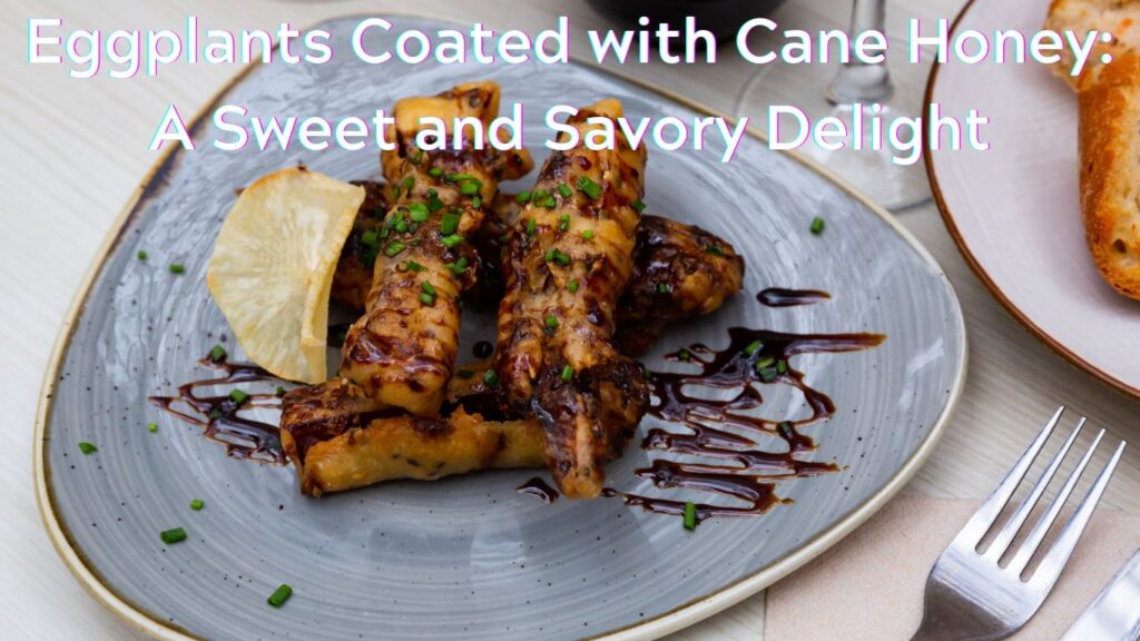 A plate of eggplants coated with cane honey, garnished with chopped herbs and a lemon wedge, presented on a ceramic plate.