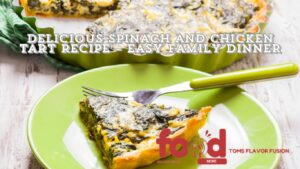 Slice of spinach and chicken tart served on a green plate with a tart dish in the background.