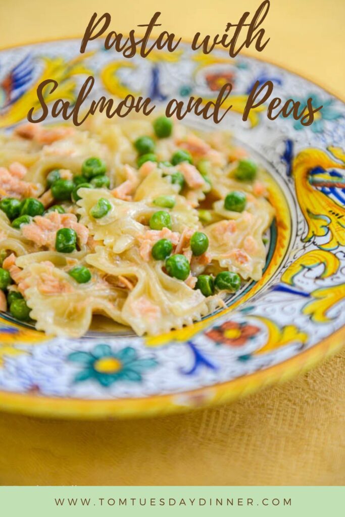 A colorful plate of pasta with salmon and peas.