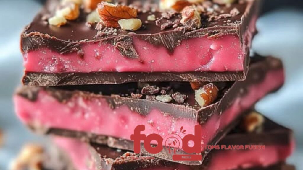 Homemade Cherry Mash Bars with a chocolate-peanut layer on top of a pink cherry layer, cut into squares.