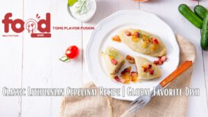 A plate of Lithuanian Cepelinai with a fork on a beige cloth, surrounded by fresh vegetables and a small bowl of sauce. The text reads "Classic Lithuanian Cepelinai Recipe | Global Favorite Dish."