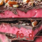 Homemade Cherry Mash Bars with a chocolate-peanut layer on top of a pink cherry layer, cut into squares.