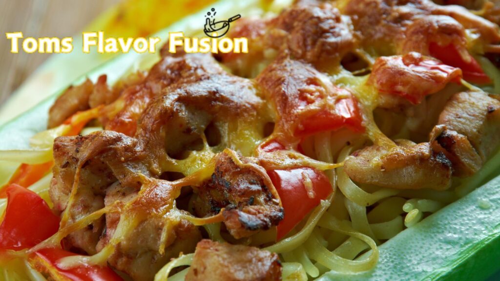 Close-up of a dish with grilled chicken, red bell peppers, and melted cheese over noodles, with the text "Toms Flavor Fusion" in the top left corner.