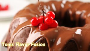 Chocolate bundt cake drizzled with smooth chocolate glaze, topped with fresh red cherries.